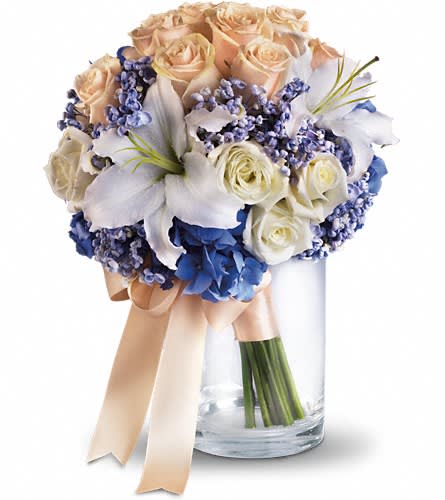 Nantucket Dreams Bouquet - T182-1A - Evoke the soft splendor of the sea with this beautiful upscale bouquet of hydrangea roses and lilies. Blue hydrangea and white lilies combine beautifully with cr?me and white roses.Approximately 11 1/2" W x 15" H Orientation: N/A As Shown : T182-1A