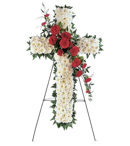 Standing floral cross with white and red flowers on an easel
