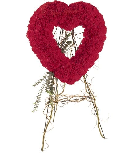 Red heart-shaped floral wreath on a stand