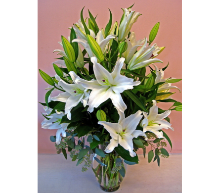 White lilies arranged in a clear glass vase