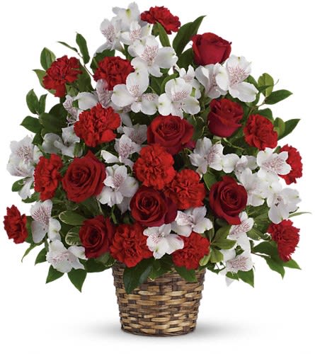 Red roses and carnations with white orchids in a woven basket