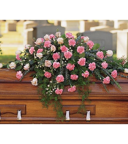 Pink carnations and pale roses arranged on a casket