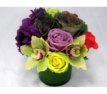 Colorful bouquet in a green vase with roses and orchids