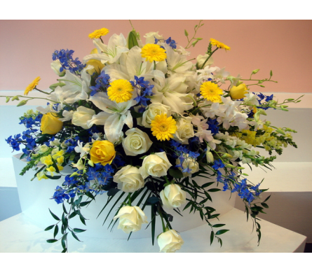 Large bouquet of white lilies, roses, and yellow daisies with blue accents