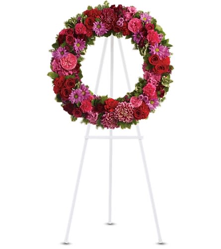 Infinite Love - T239-2A - This beautiful wreath stands as a testament to the circle of life that must be acknowledged even in our saddest moments. It will surely be appreciated by all in attendance. Dazzling blooms such as pink hydrangea hot pink roses and carnations red roses spray roses and carnations burgundy dahlias dark pink Sweet William lavender daisy and button spray chrysanthemums along with fern and other fresh greens create a beautiful wreath that comes delivered on an easel.Approximately 27" W x 27" H Orientation: One-Sided As Shown : T239-2A