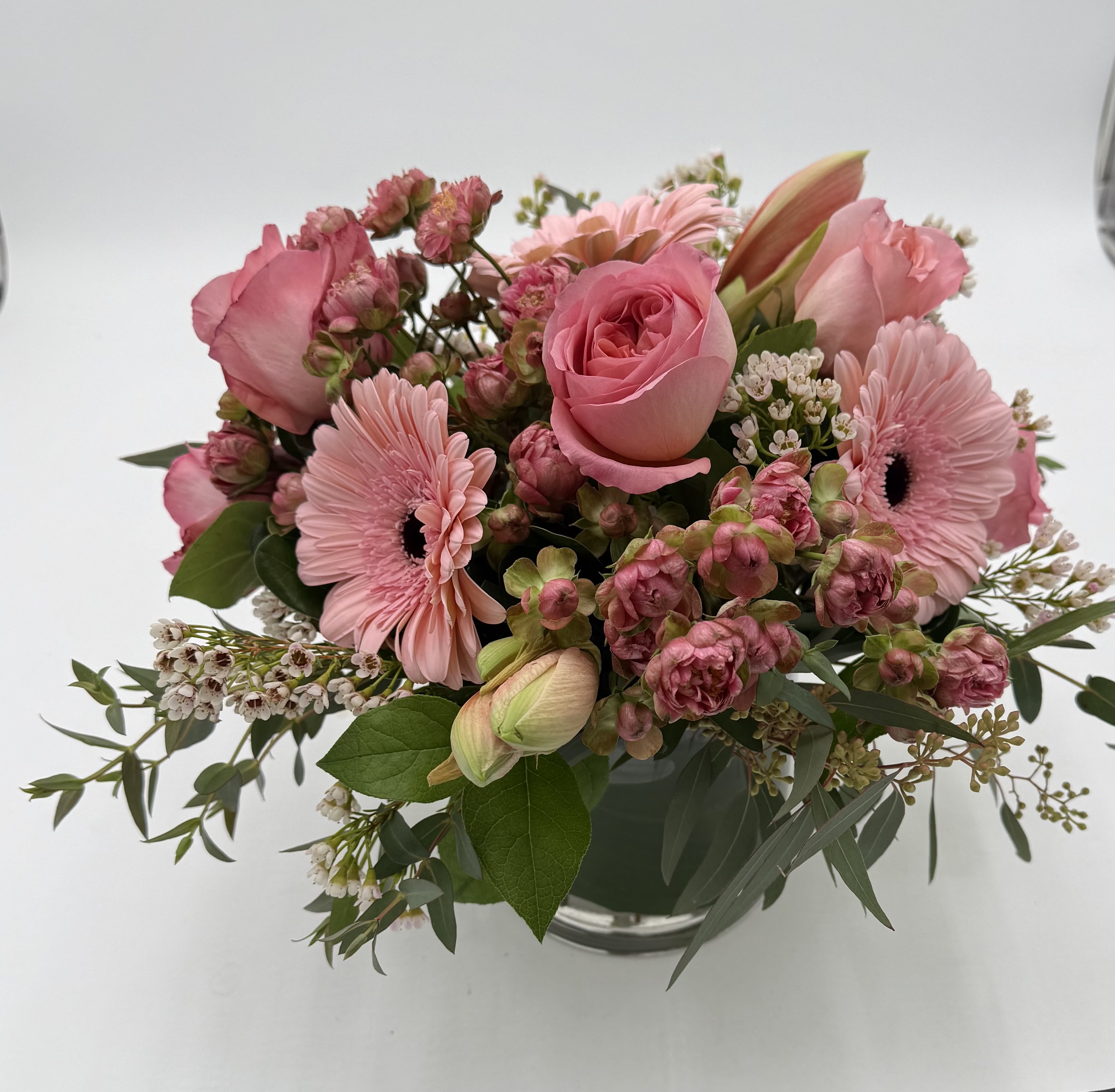 Rosey Posey - Monochramatic arrangement in a clear vase.  Roses, spray roses, gerbera daisies,  and eucalyptus in shades of pink.