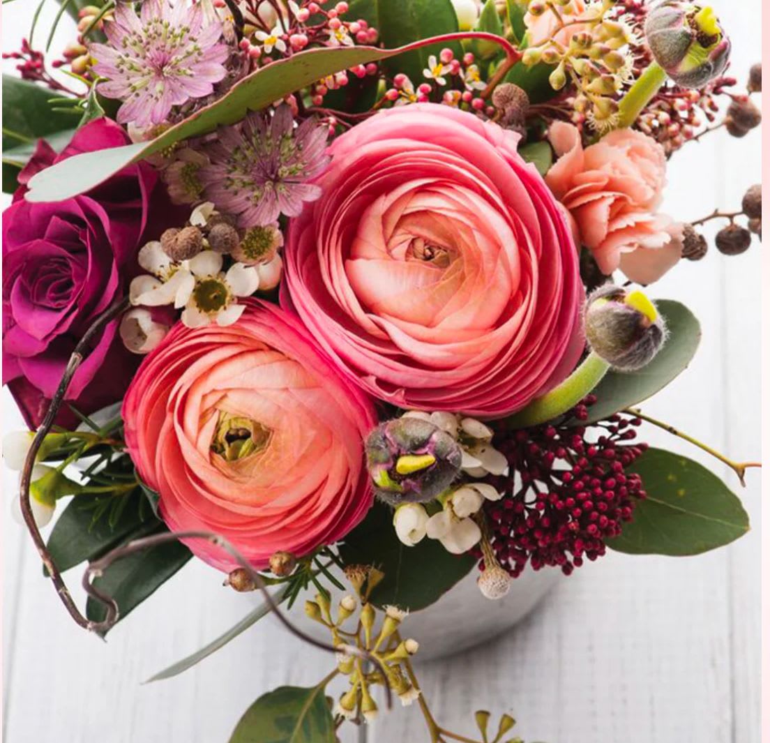 Scentiments - Ranunculus, roses and waxflower in shades of purples, corals and pinks.