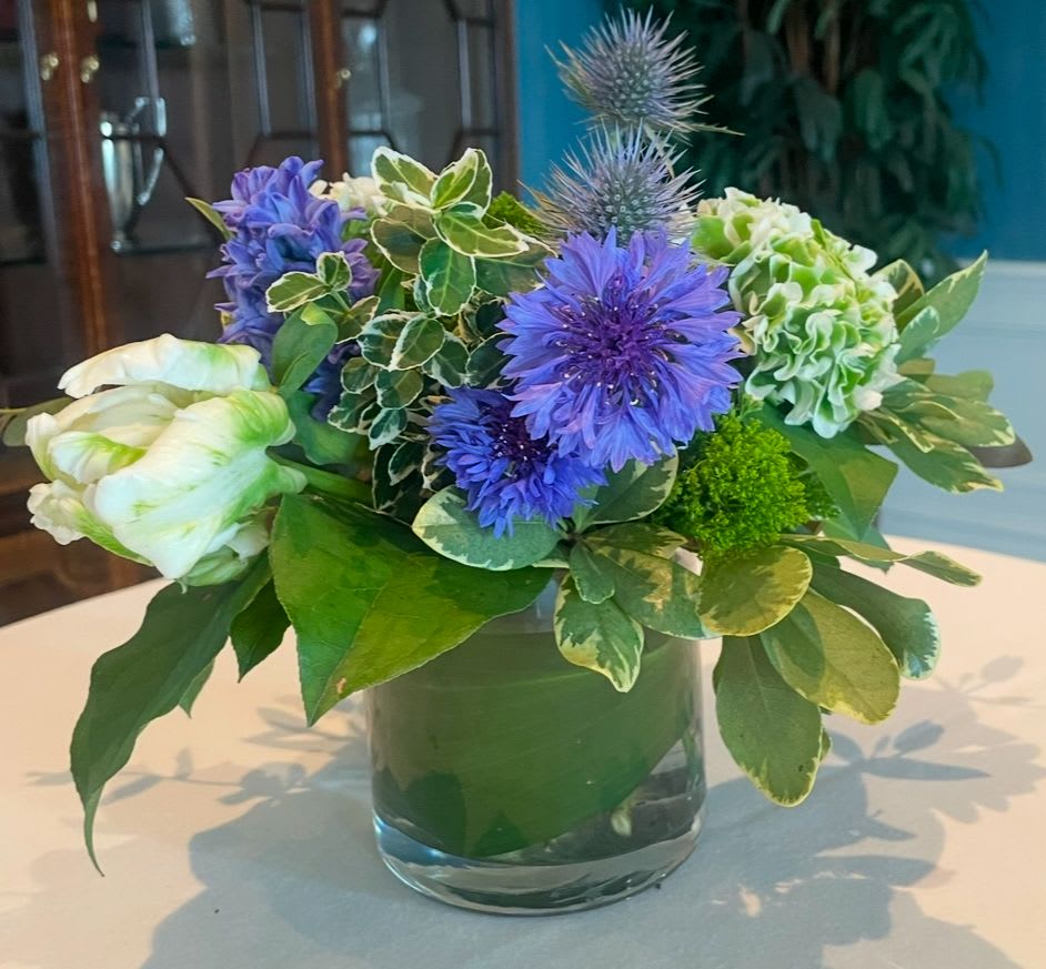 Simple joys - Bachelor buttons, tulips, hyacinth, ranunculus, dianthus and thistle in shades of green and purple in a vase.