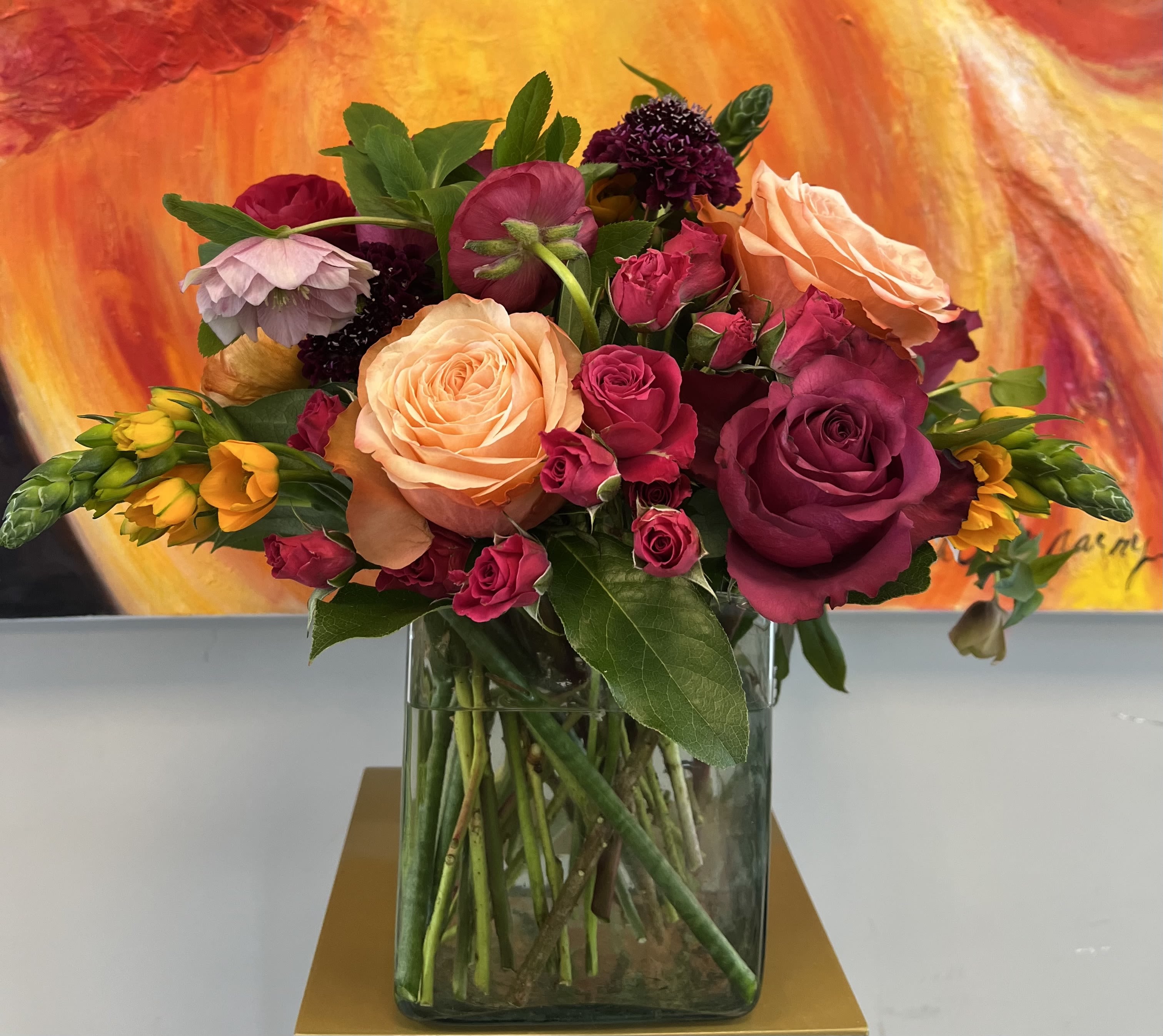 Vibrant Jewel - Roses, spray roses, hellebores, scabiosa with mixed greens in a vase 