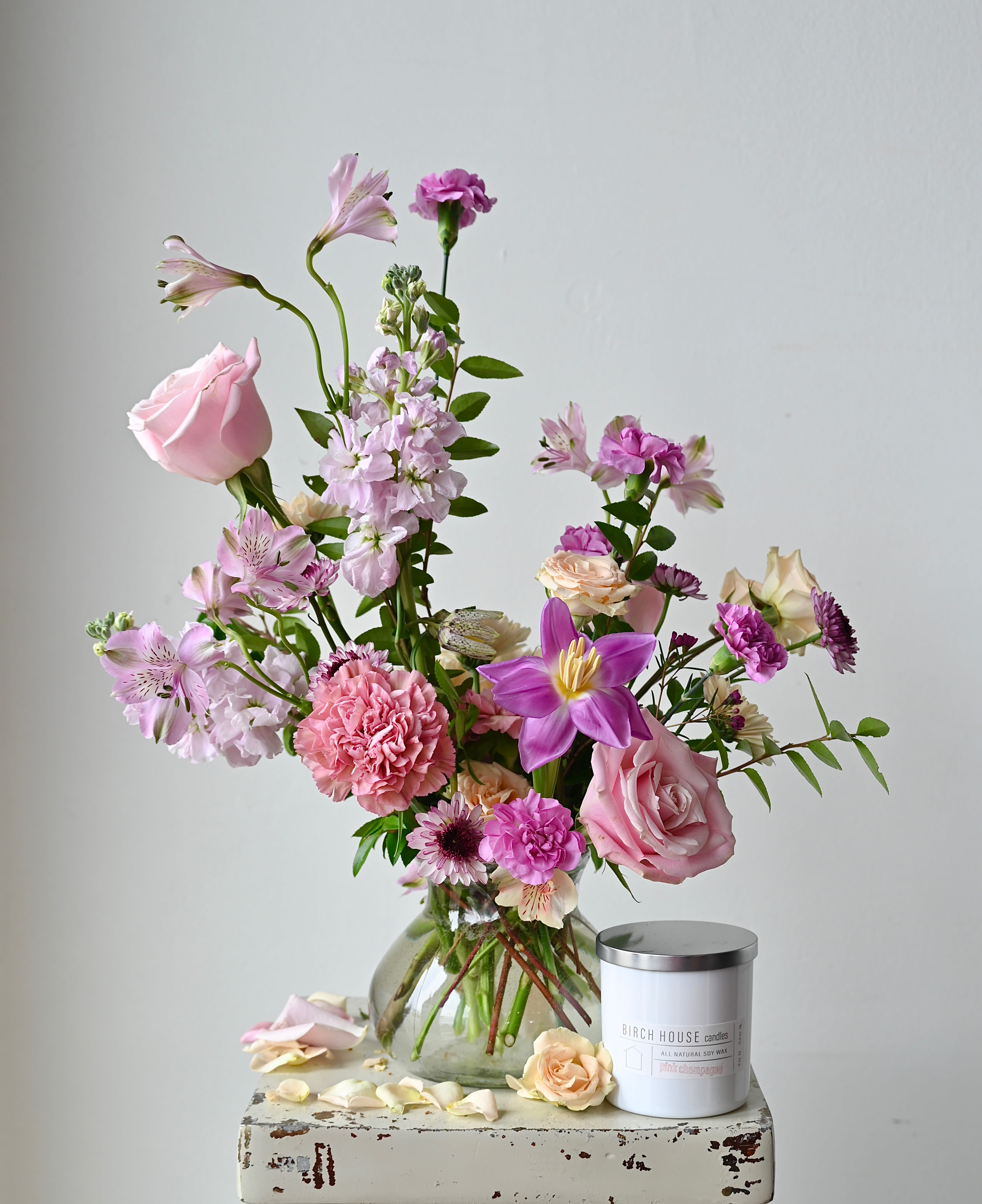 THE POSIE BUNDLE - A beautiful arrangement designed in our adorable posie vase and accompanied with a deliciously fragrant Birch House Candle.  Candle hand-selected by one of our staff members.  *Please note that our selection of flowers and color palette changes from week to week and all substitutions will be of equal value. 