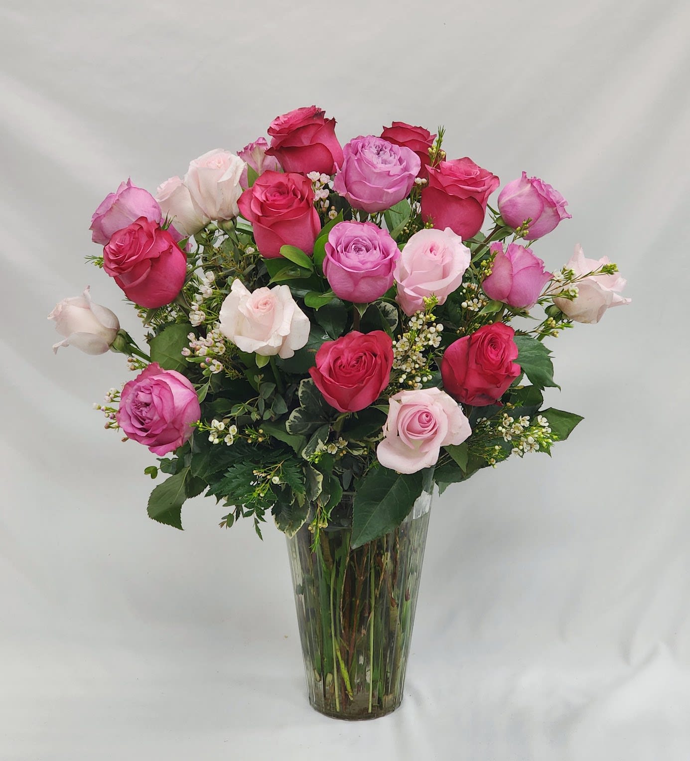 Long Stem Two Dozen Mixed Pink Roses - Select this long stemmed two dozen arrangement featuring mixed pink roses, greenery and filler flower. Filler flower will vary.