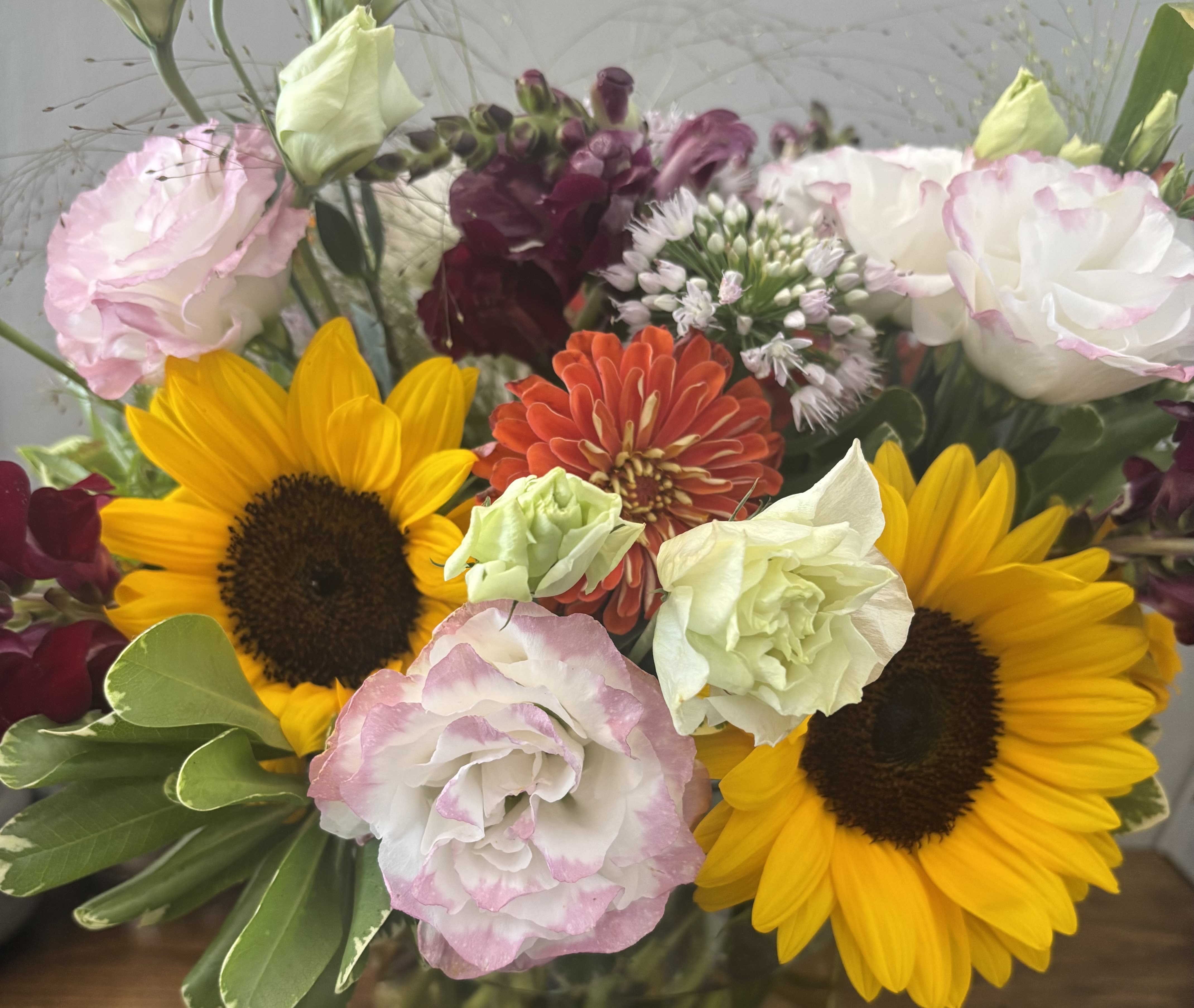 Mixed bouquet with sunflowers, pink and white blooms, and burgundy flowers