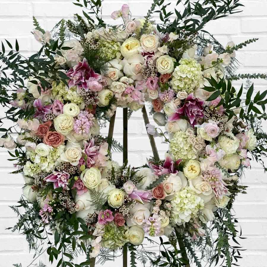 Large floral wreath with pale roses, hydrangeas, and pink lilies