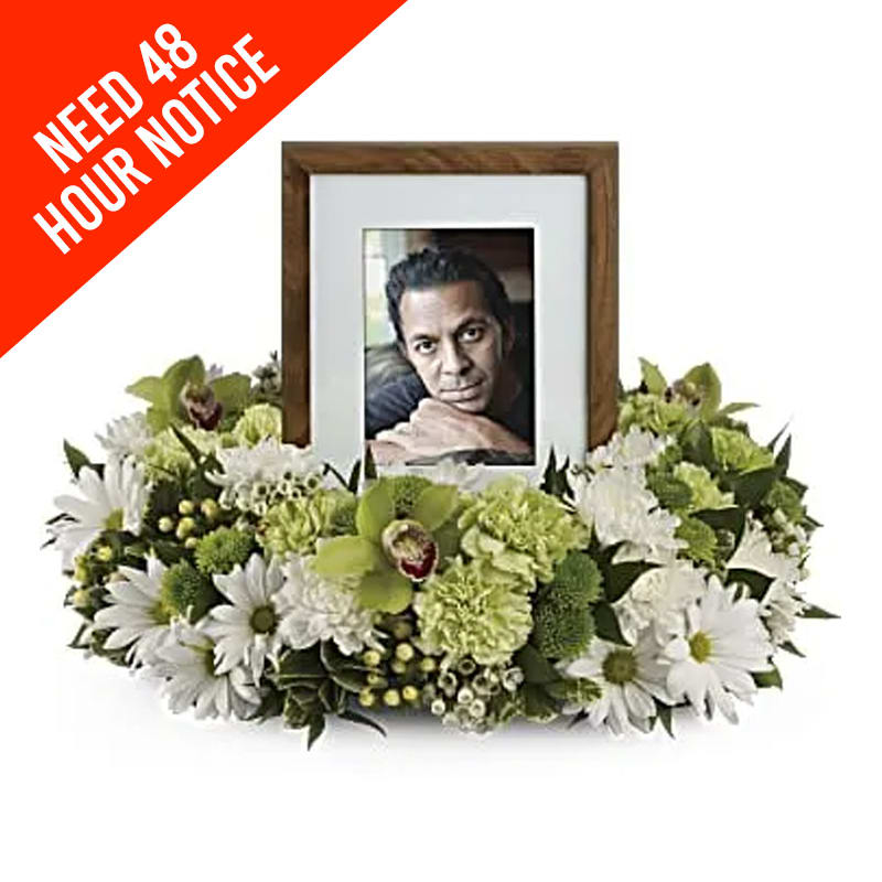White and green sympathy frame surrounded by flowers