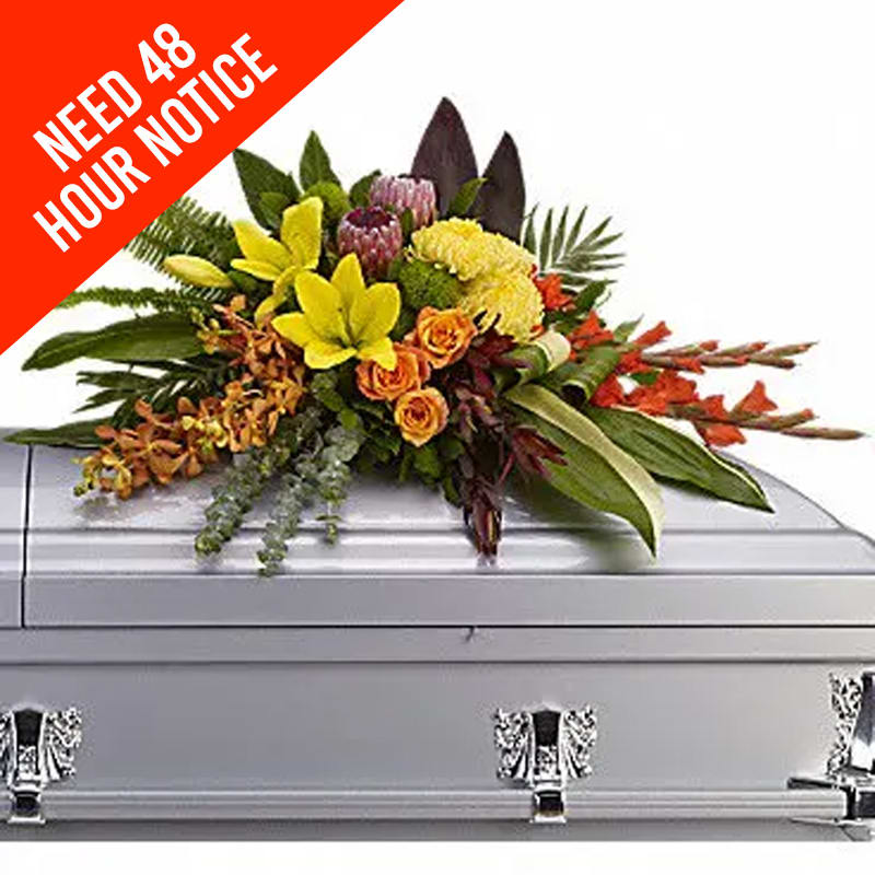 Colorful floral casket spray on a silver casket