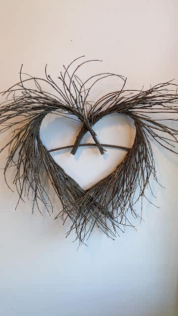 Heart-shaped twig wall hanging with wispy branches at the top