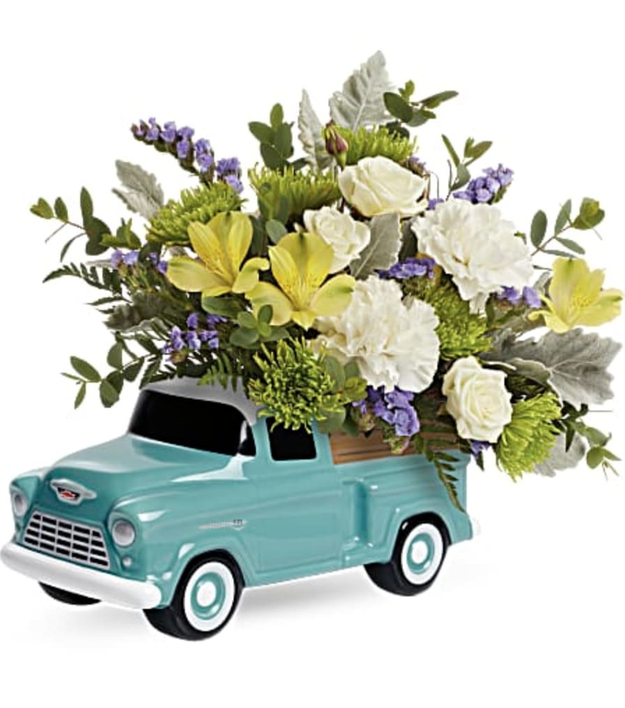 Bouquet of white and yellow flowers arranged in a turquoise toy truck