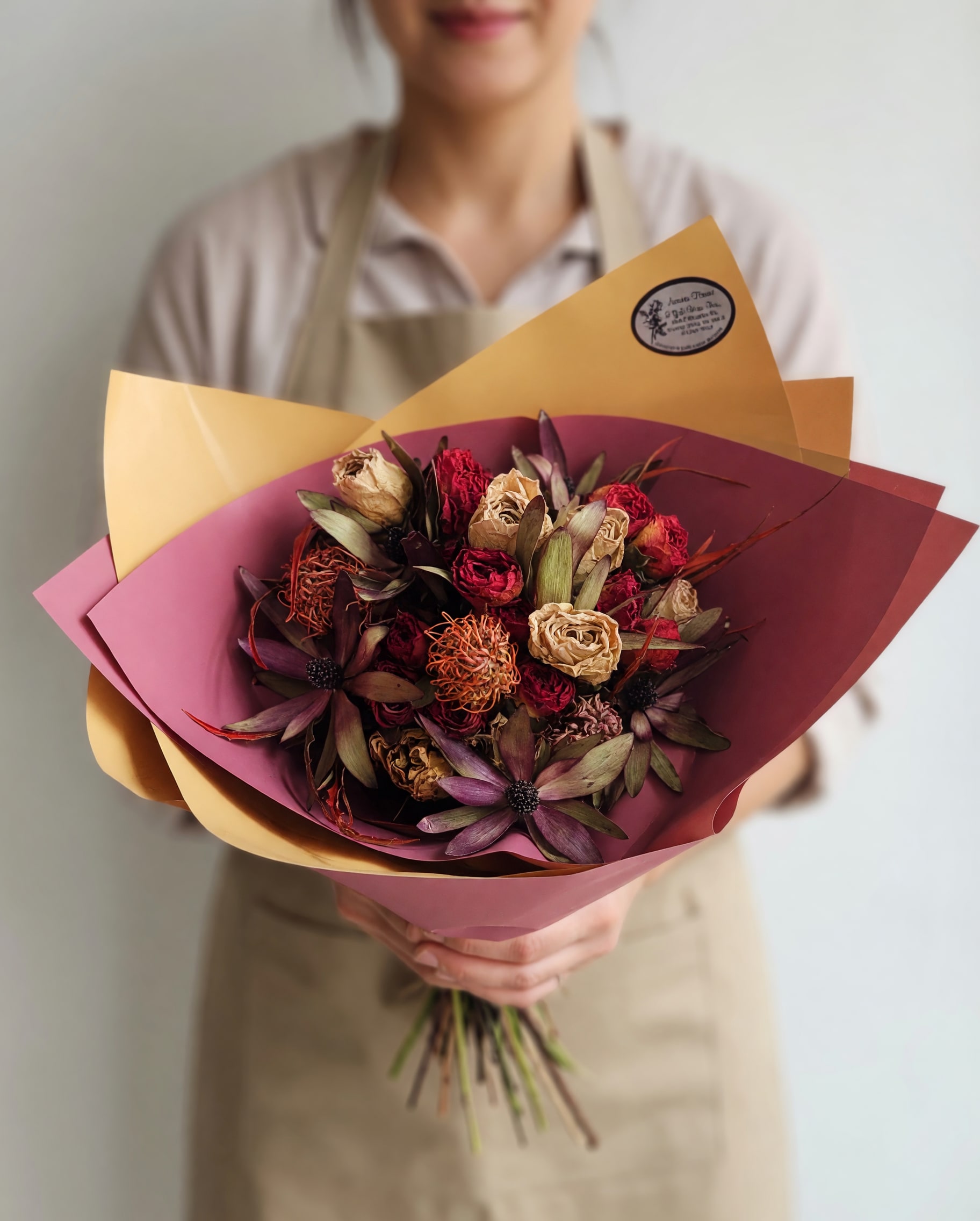 Autumnal Auburn Dried Bouquet  - Deep, romantic dried roses and textured star-shaped blooms make this Autumnal Auburn Dried Bouquet an unforgettable anniversary or thank-you gift that feels both vintage and carefully curated. As a fall-ready bouquet for Thanksgiving or a warm housewarming present, its muted purple, dusty rose, deep burgundy and tan palette reads as cozy and refined-perfect for saying "I'm thinking of you".