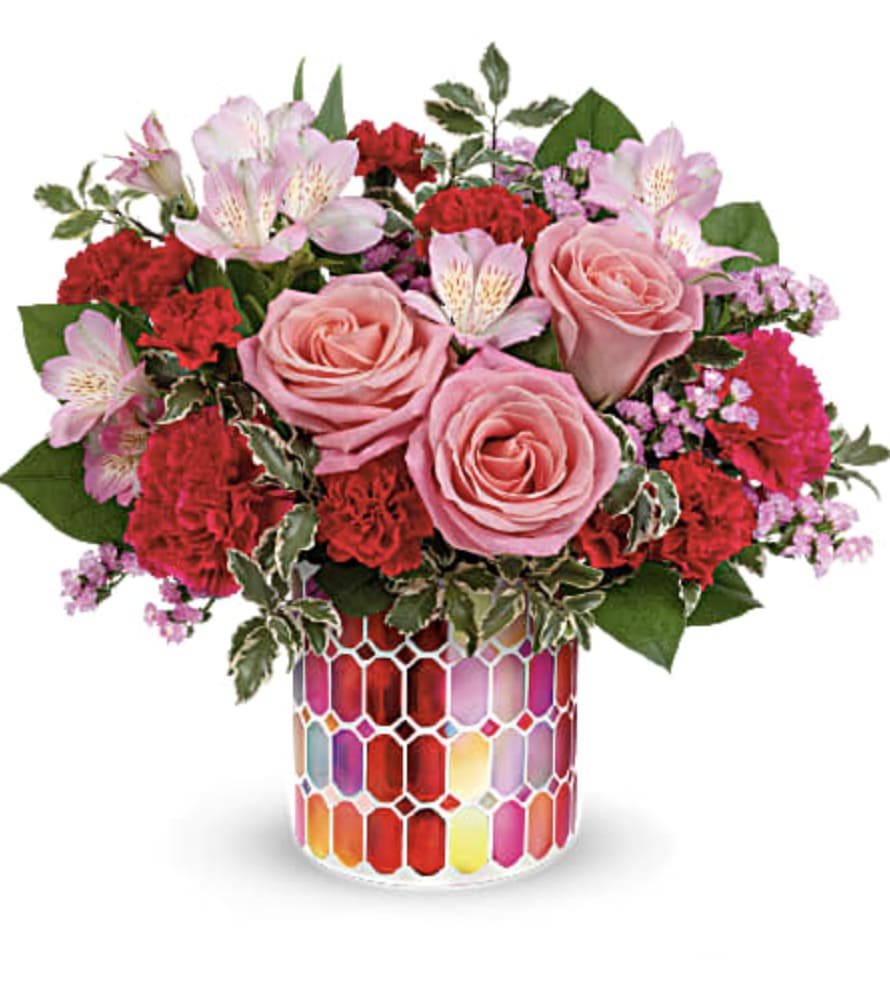 Pink roses and red carnations in a colorful mosaic vase