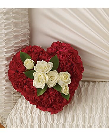 A Devoted Heart Casket Insert - Such a simple tribute, this lovely casket bouquet of white roses enclosed in a heart of red carnations is a profoundly moving symbol of never-ending love. The sweet bouquet includes white spray roses surrounded by red miniature carnations formed in the shape of a heart. 6Wx6H