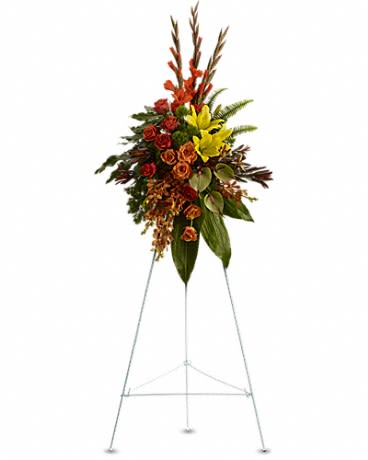 Tall floral standing spray with red, yellow, and orange blooms on an easel