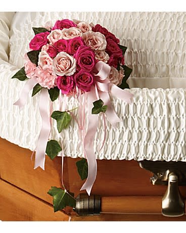 Rose Reflection Casket Insert - A beautiful gesture, this lovely array of pink spray roses and pink carnations inside the casket inspires a feeling of closeness with the lost loved one. The delicate bouquet includes hot pink spray roses and light pink miniature carnations tied with pink satin ribbon, accented with green ivy. 9Wx14H