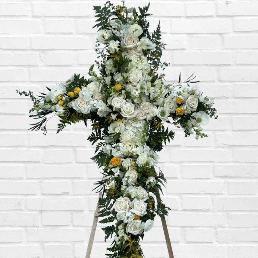 Cross-shaped floral arrangement of white roses and yellow blooms