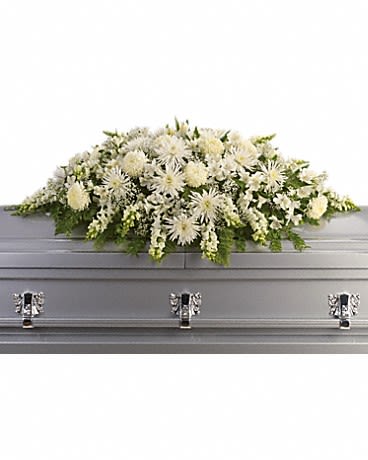 White floral casket spray on a gray casket