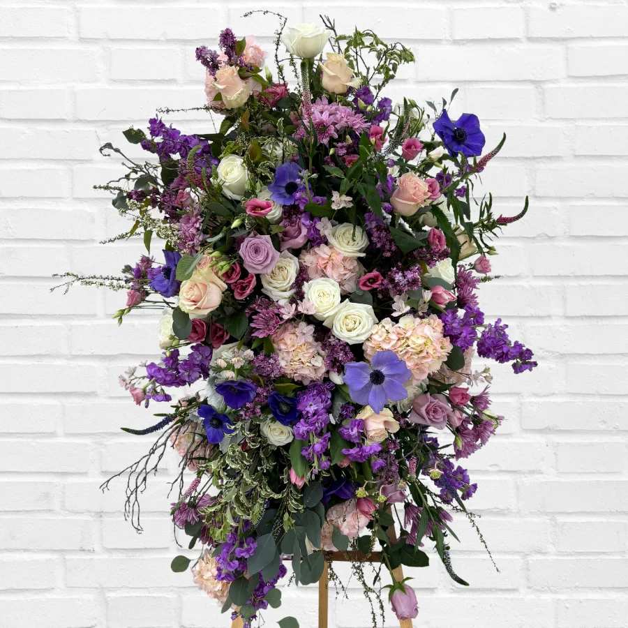 Tall standing floral spray with purple, pink, and white blooms