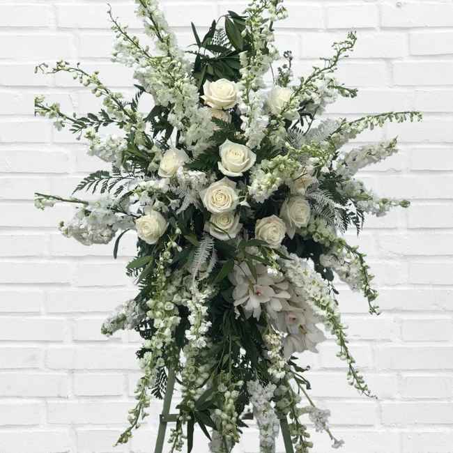 Tall white floral standing arrangement with roses and cascading blooms