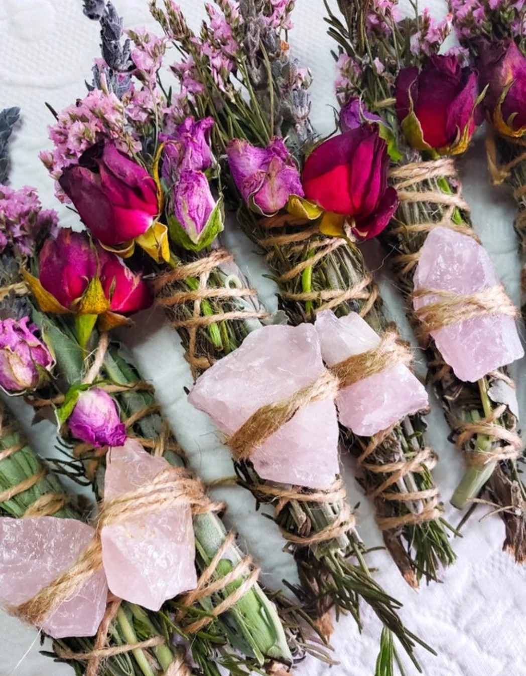 Small bundled rose bouquets tied with twine and pink stones