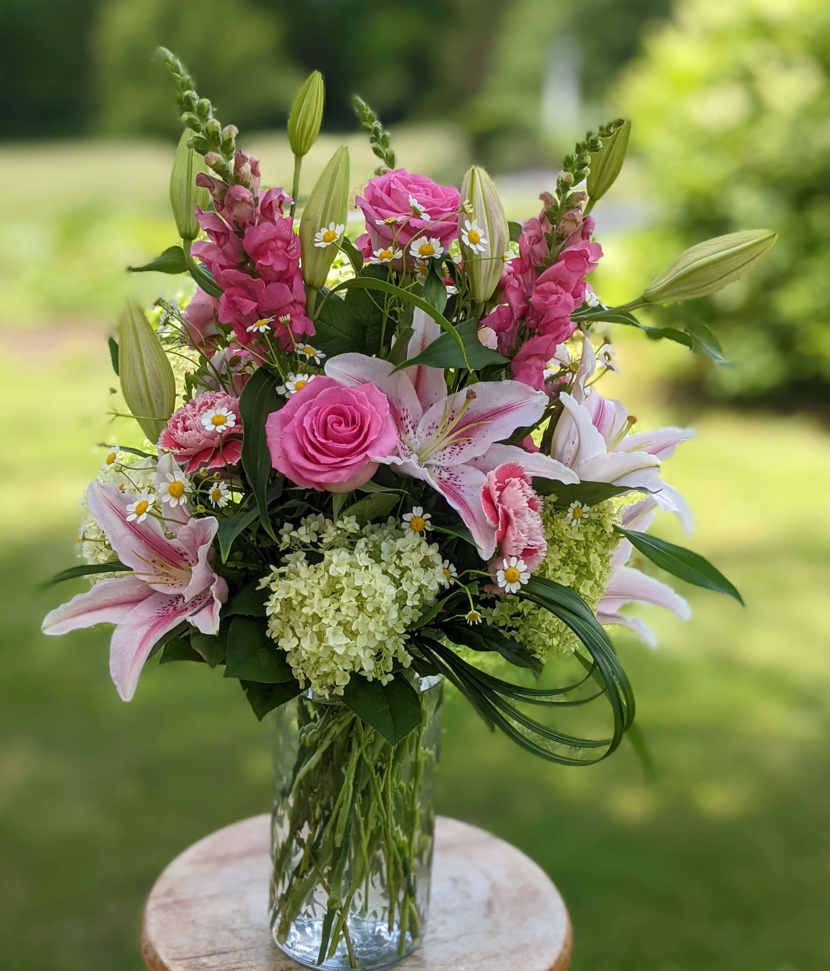 Pink and white floral arrangement in a clear glass vase