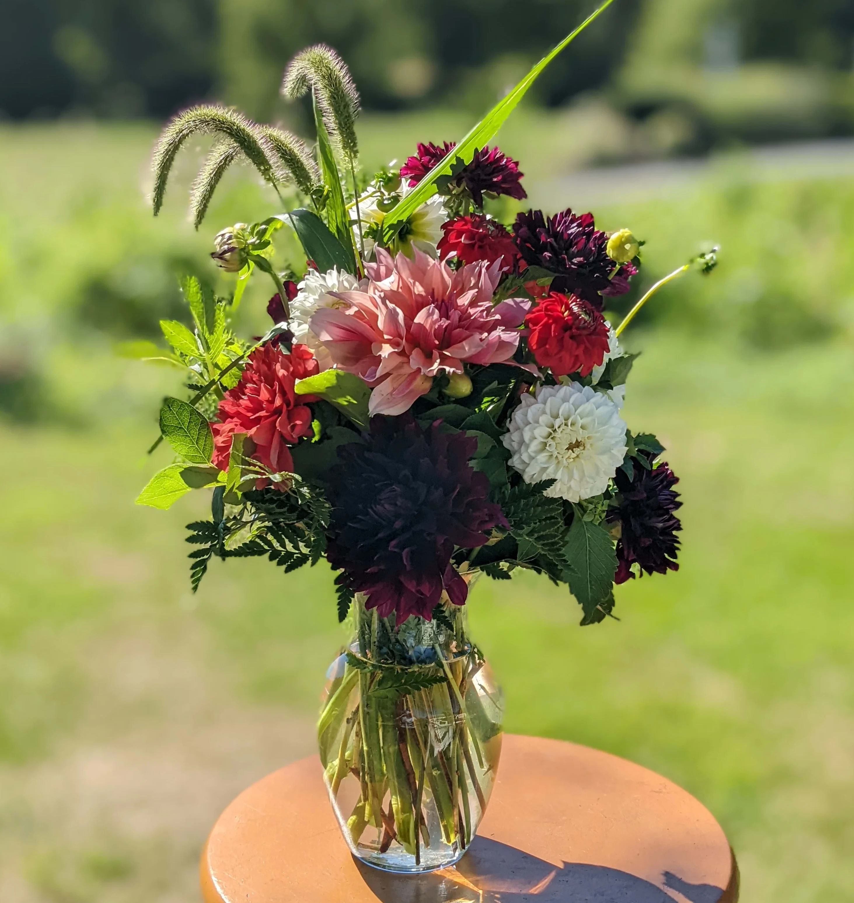Mixed bouquet of dahlias and chrysanthemums in a clear glass vase