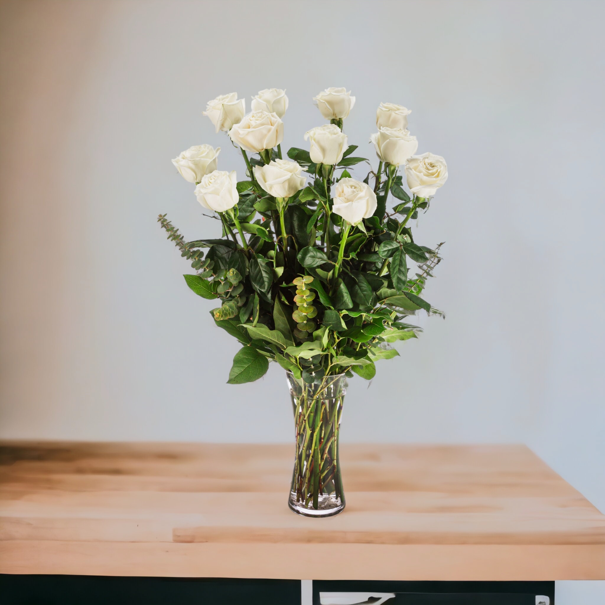 White roses arranged in a clear glass vase