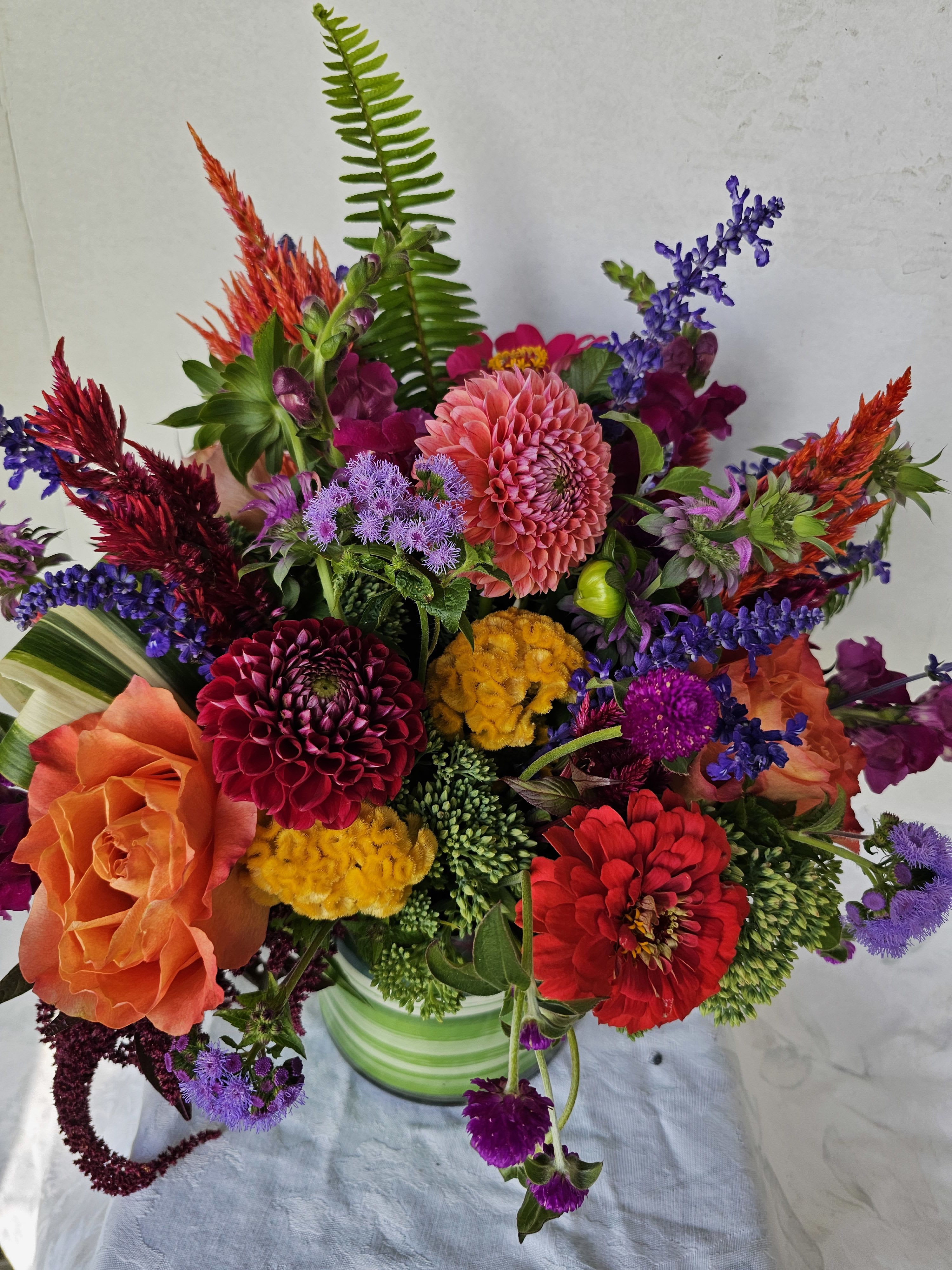 Colorful mixed bouquet in a striped green vase