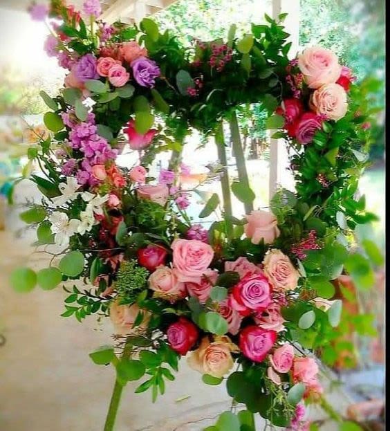 Heart-shaped floral wreath with pink and purple roses and greenery