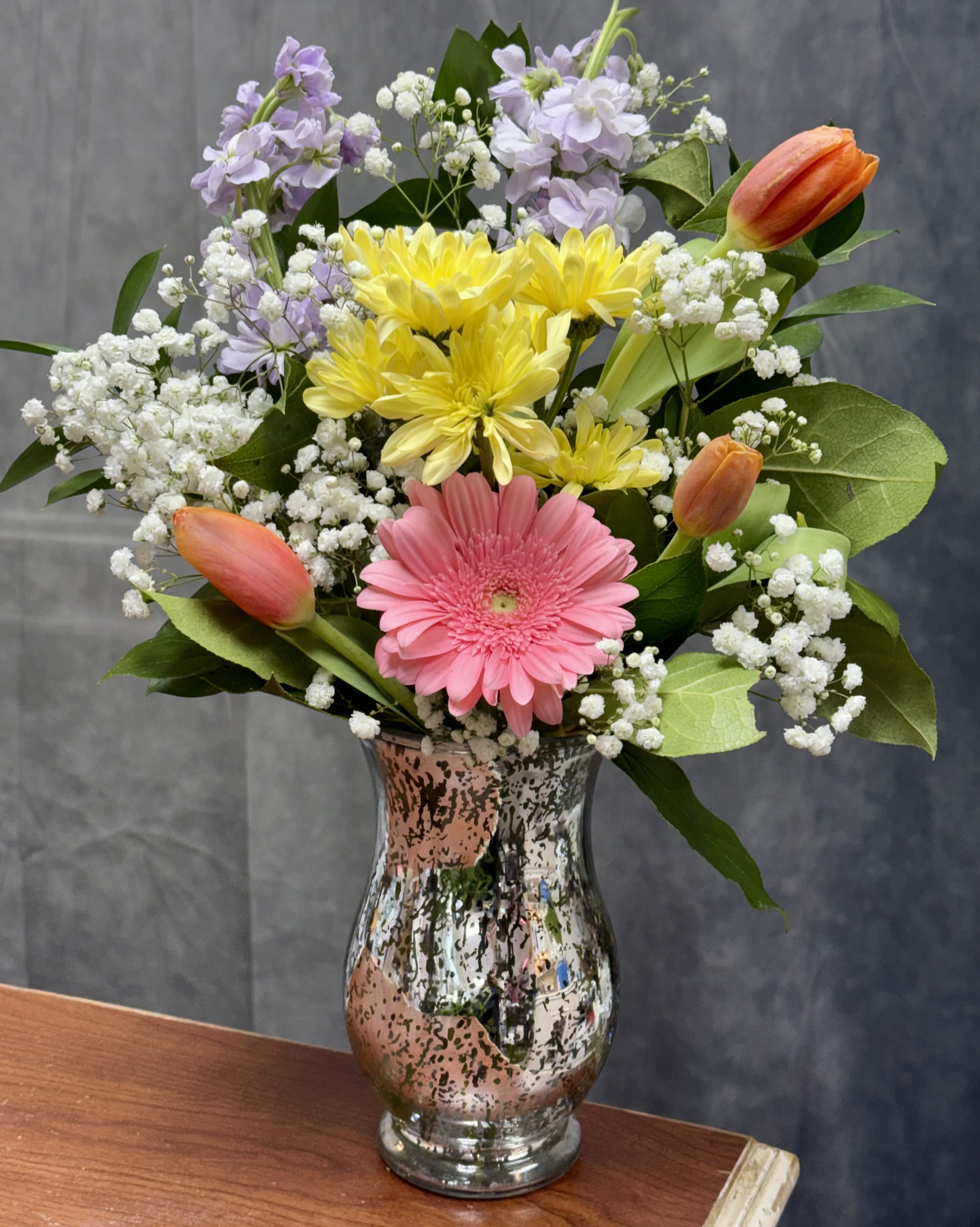 Joyful petals - A cheerful arrangement featuring tulips, gerbera daisies mix with different flowers in a shimmering glass vase . Perfect for birthday, thinking of you or brightening someone’s day