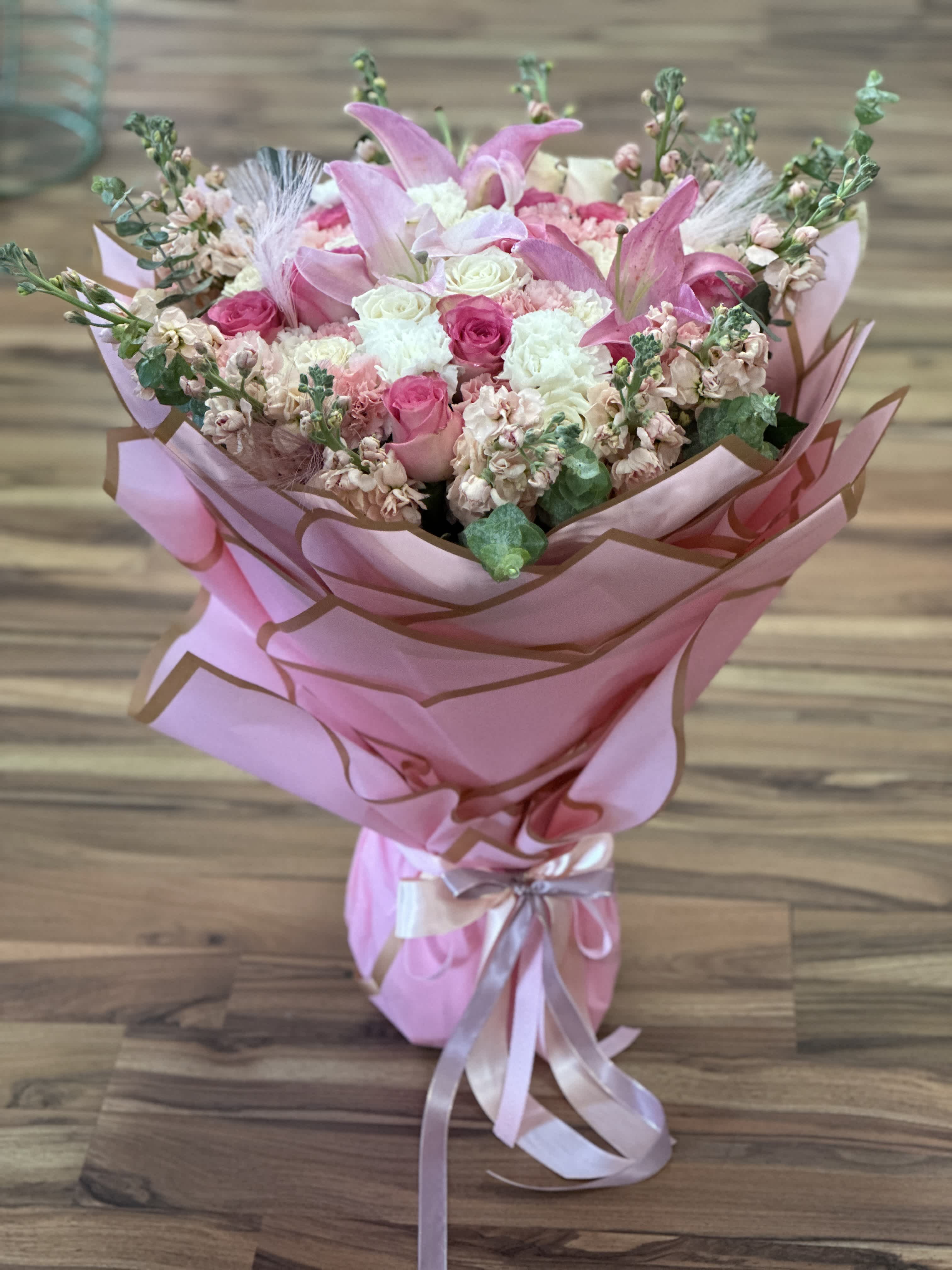 Pink bouquet with roses and lilies wrapped in pink paper