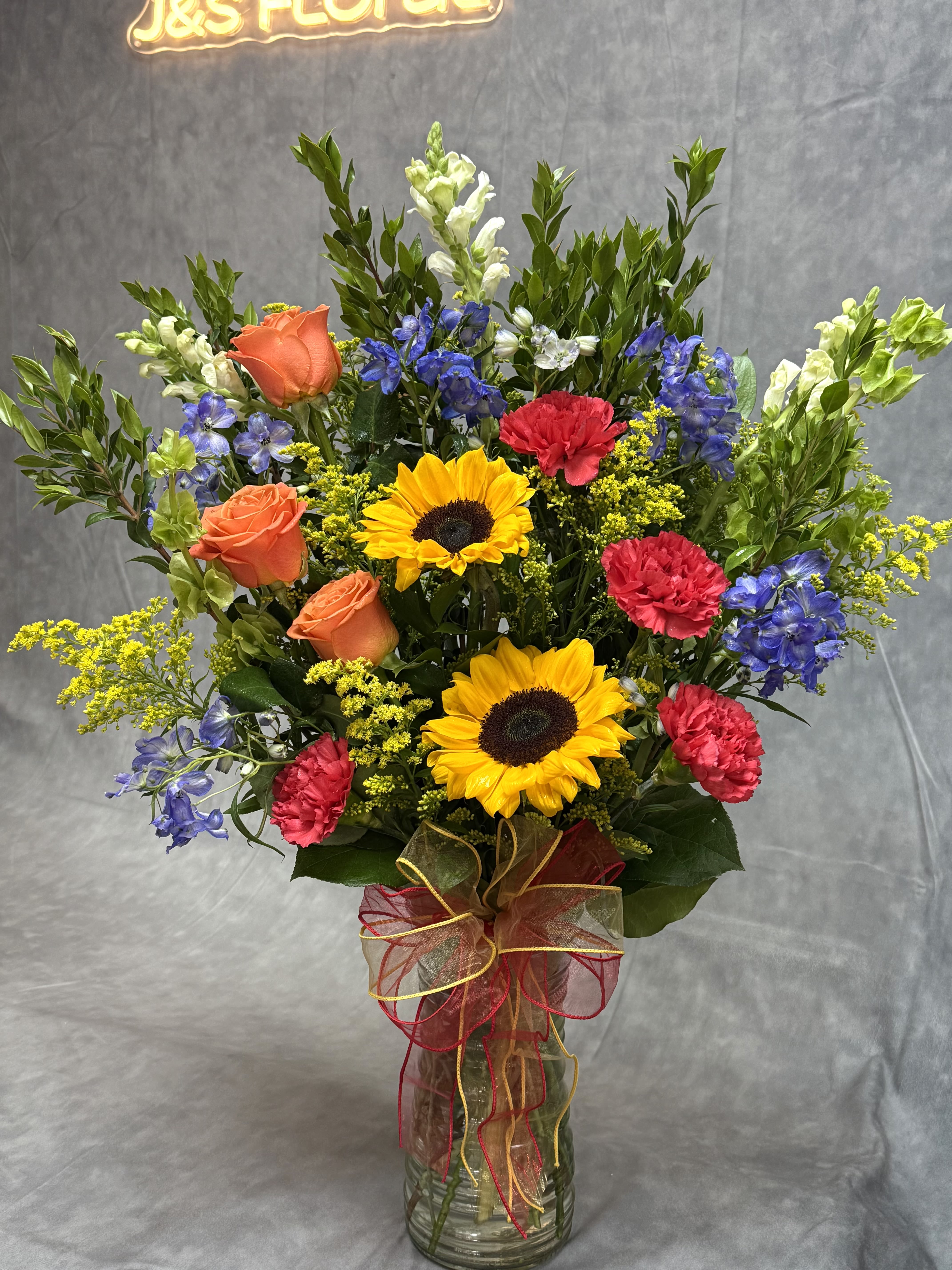 Colorful mixed bouquet in a glass vase with ribbon