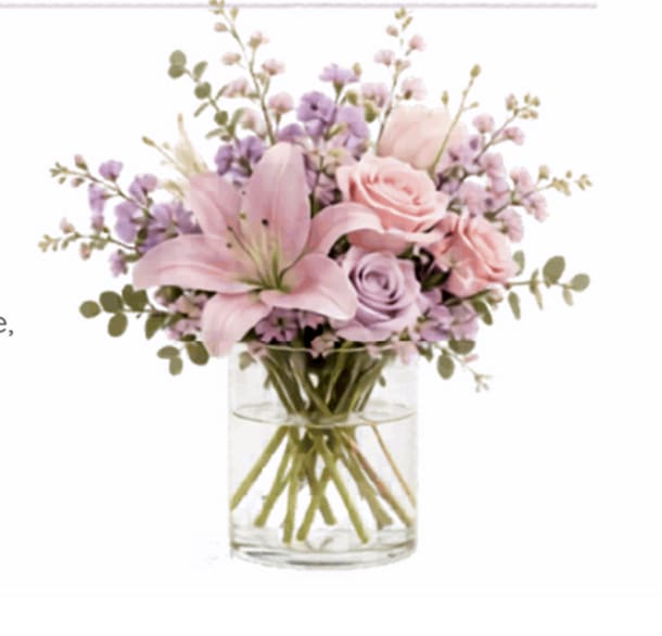 Pink and lavender flowers arranged in a clear glass vase