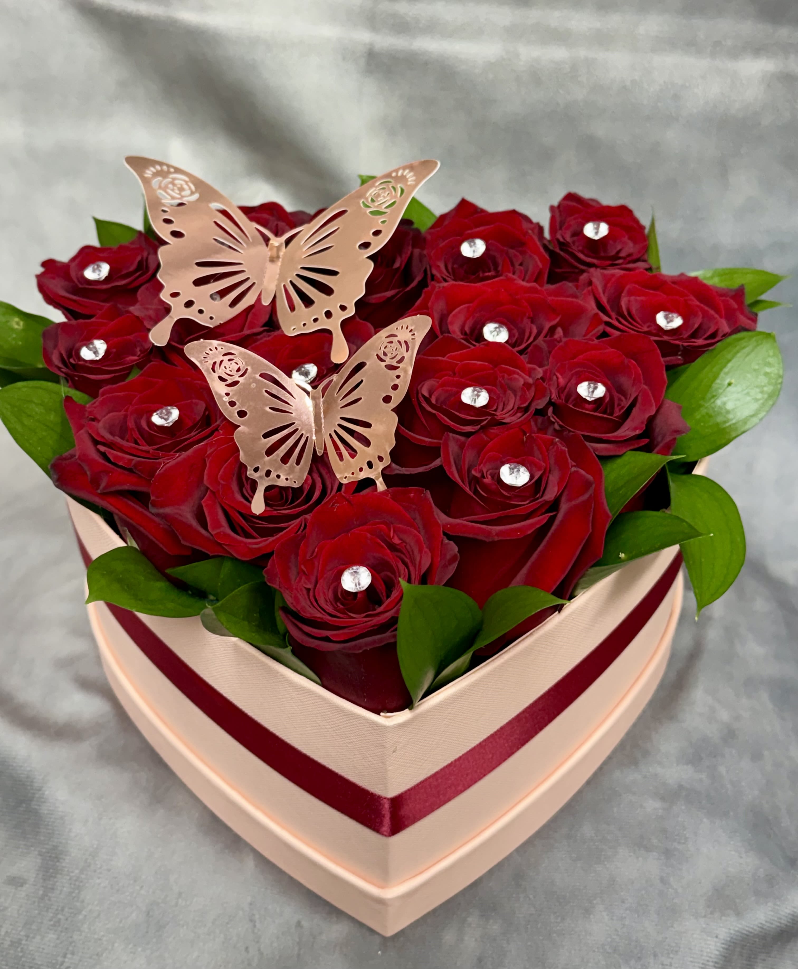 My Rosie Heart  - A luxurious heart-shaped box filled with 14 rich red roses, golden butterfly accents, and Diamonds crafted to express deep love, elegance, and devotion. Deluxe Size has 6 Ferrero chocolate with 14 Red Roses.  