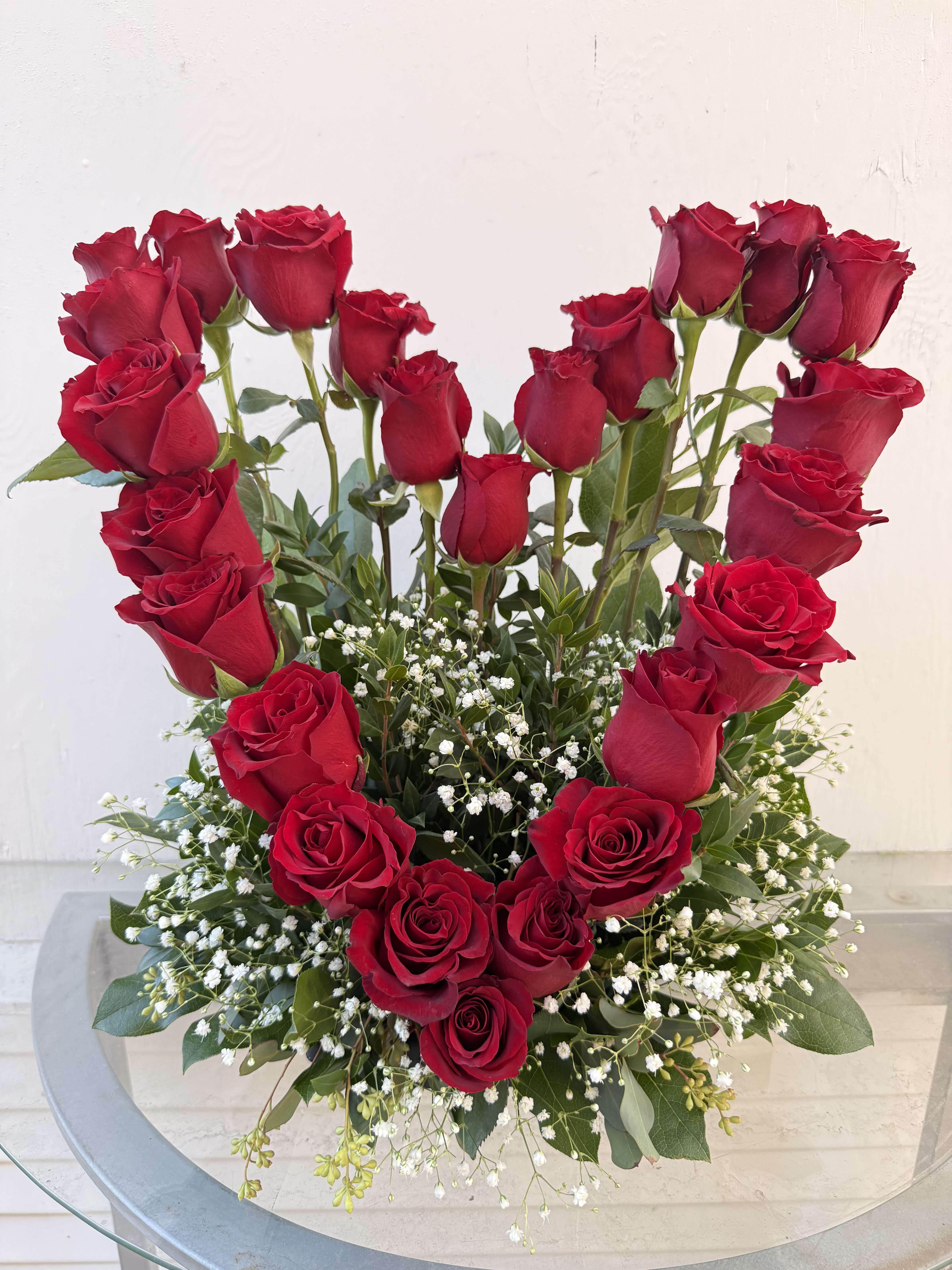 Heart-shaped arrangement of red roses with baby's breath