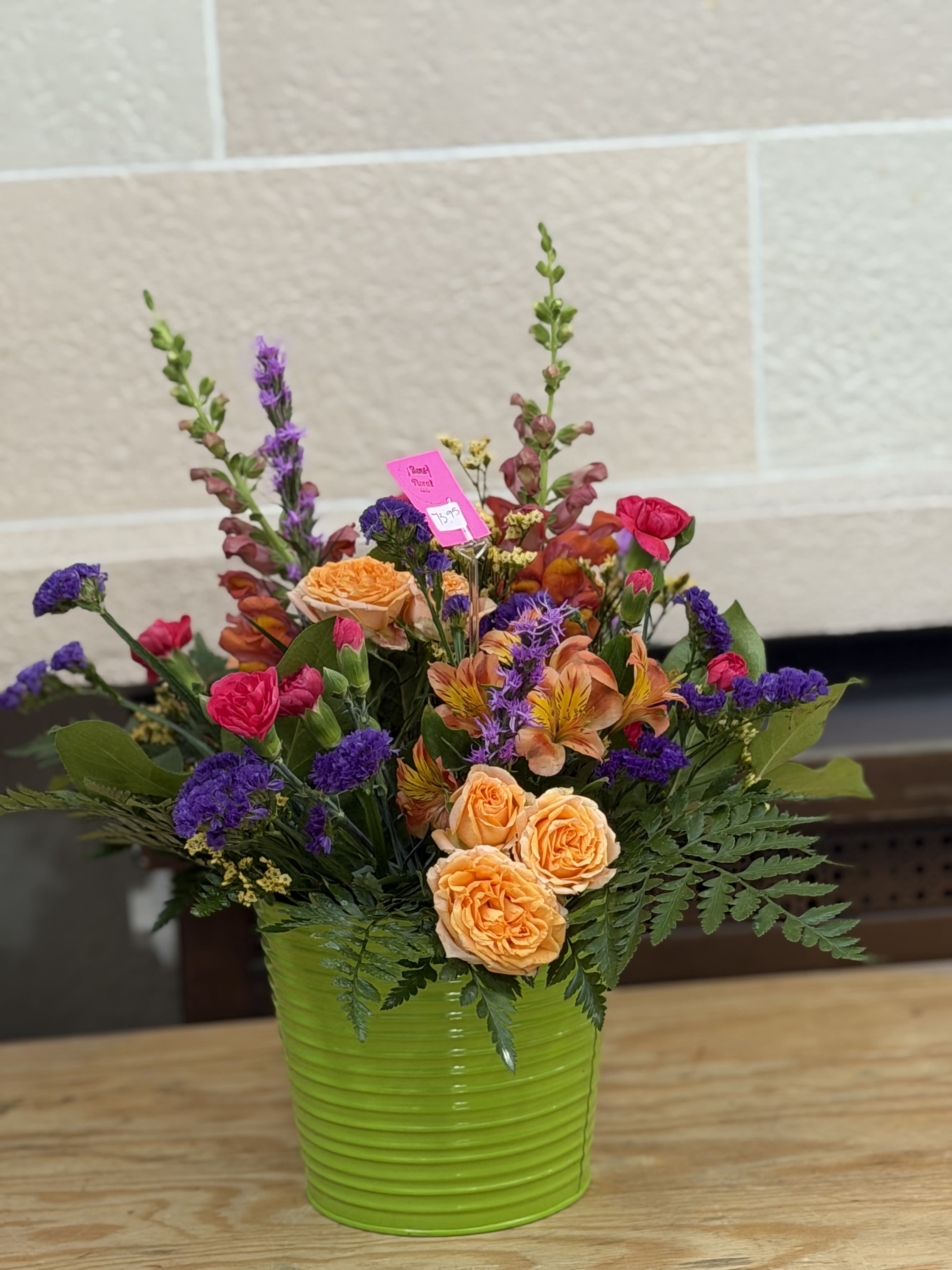 Bright Bucket of Blooms - A tin bucket filled with bright blooms including spray roses, statice, mini carnations and more. 
