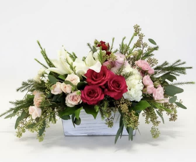 Mixed bouquet in a white wooden box with red, pink, and white flowers
