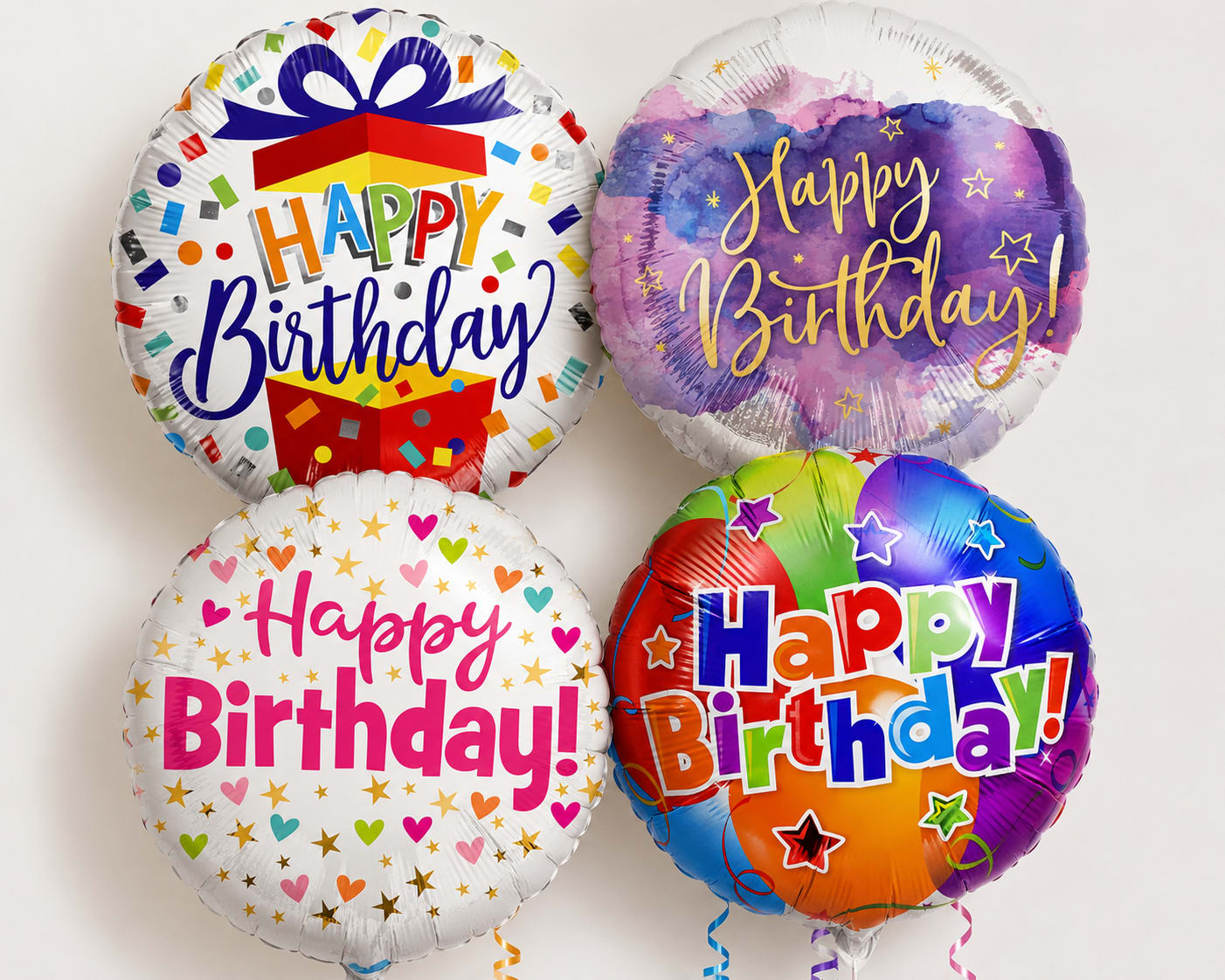 Four round birthday balloons with colorful "Happy Birthday" designs