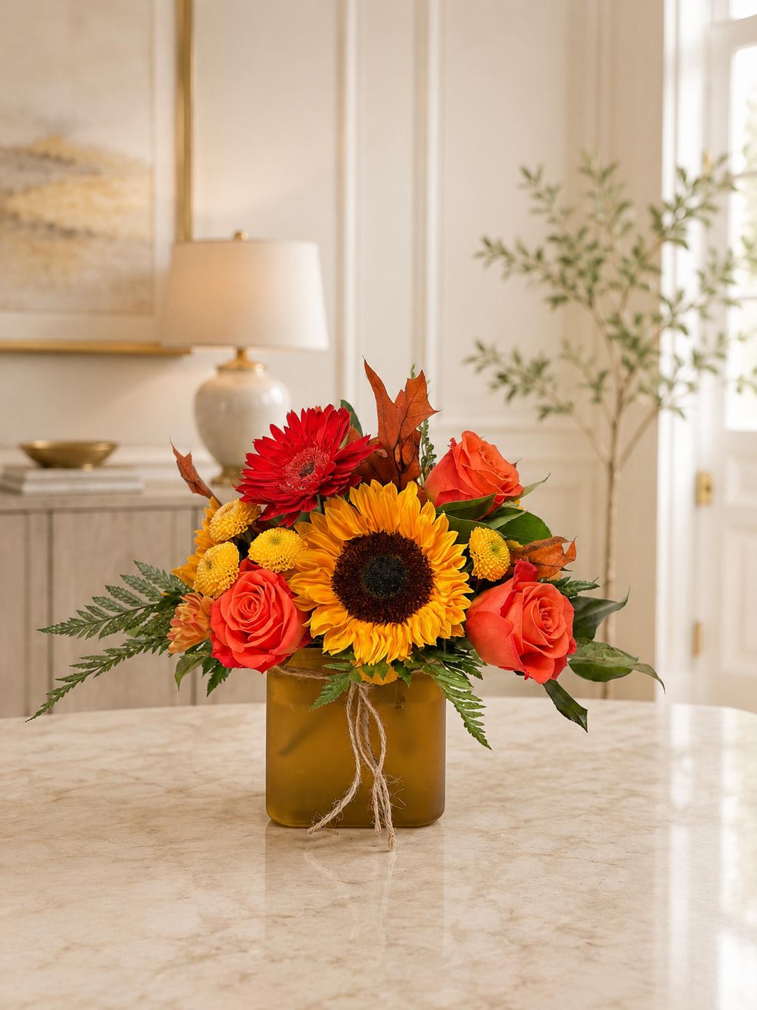 Sunflower and rose arrangement in a square amber vase