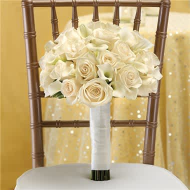 White rose and calla lily bouquet tied with white ribbon on a chair