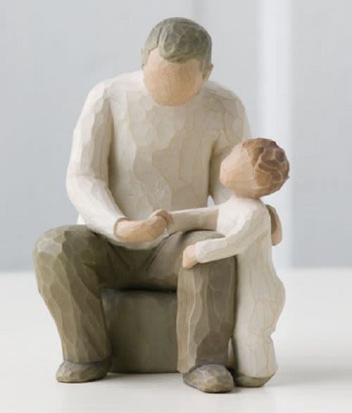 Wooden figurine of an adult and child sitting together