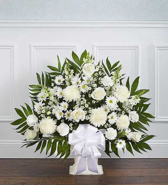 White floral standing spray with a large ribbon bow