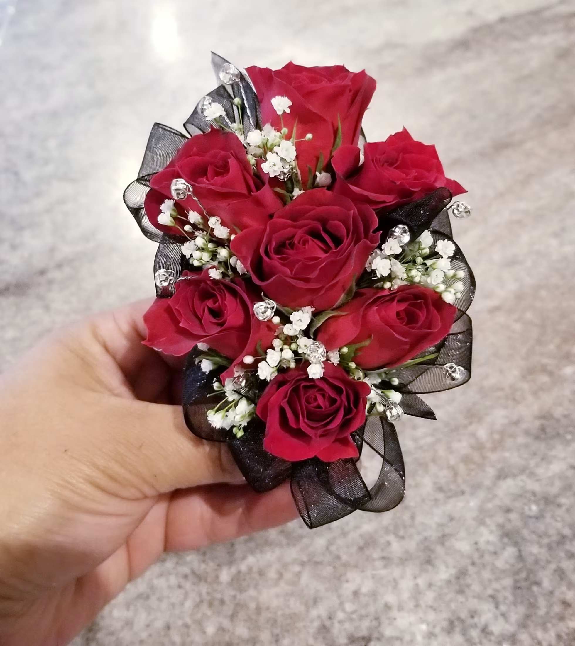 Red Rose Corsage with Black Ribbon - A classic red rose and baby's breath corsage compliments any outfit. Perfect for prom, homecoming, formal, and weddings.